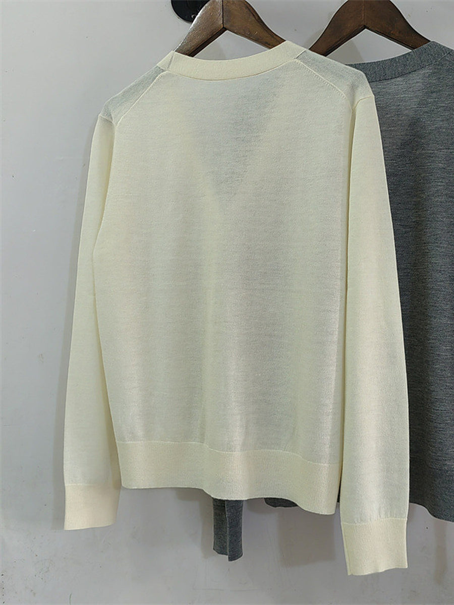 The ivory cardigan on a hanger, back