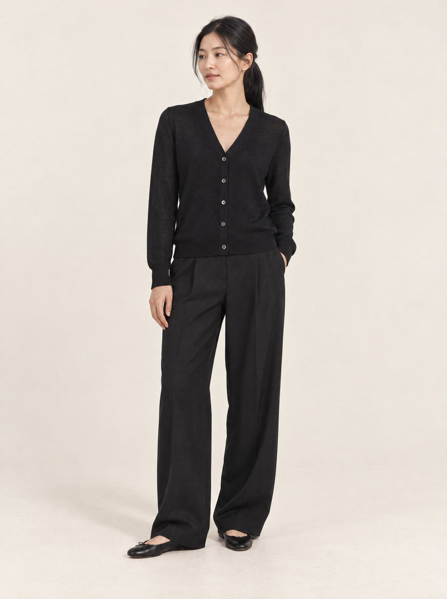 Black V-neck cardigan, buttoned, in the studio