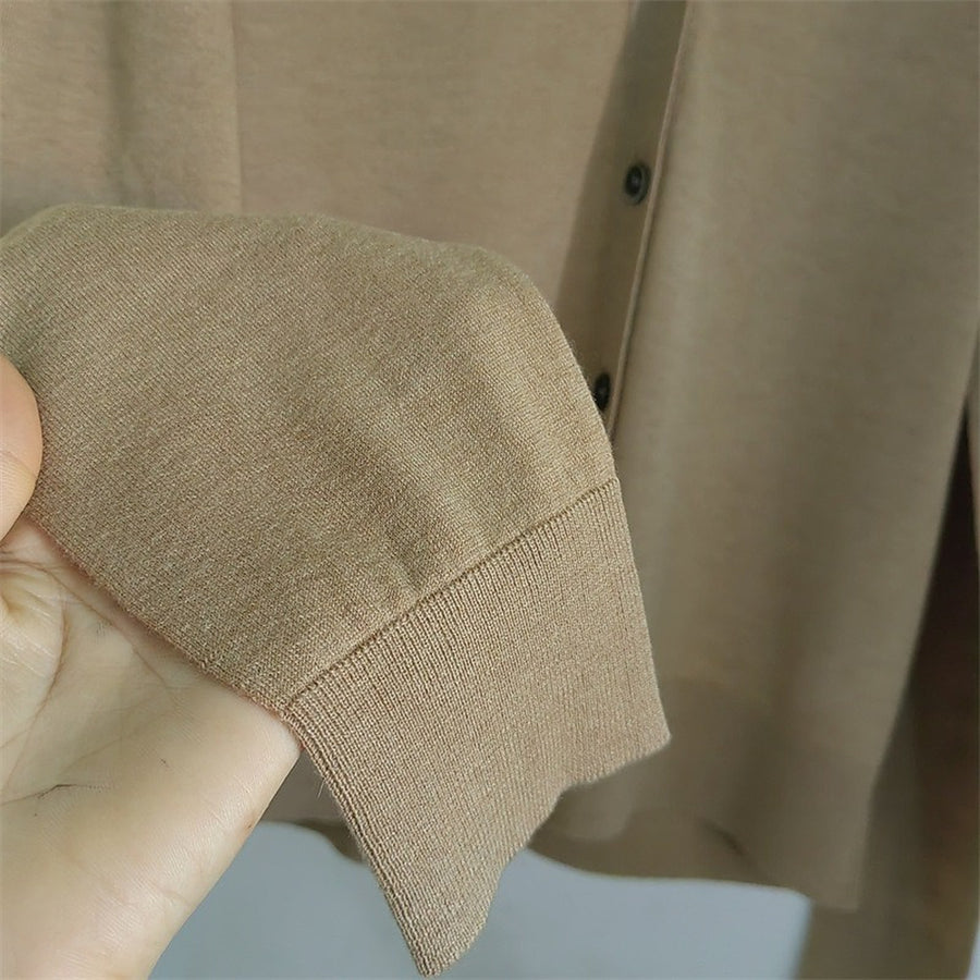 A hand holding the thin sleeve and ribbed cuff
