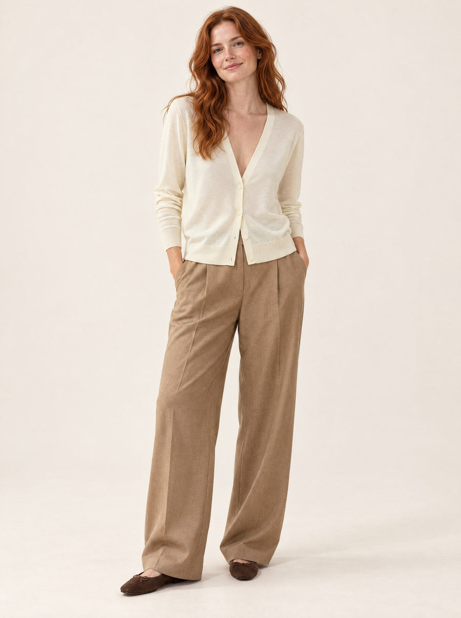 Ivory V-neck cardigan with camel trousers, in the studio