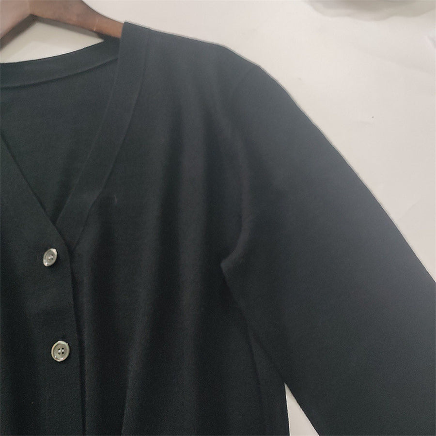 The V-neck and buttons of the black cardigan