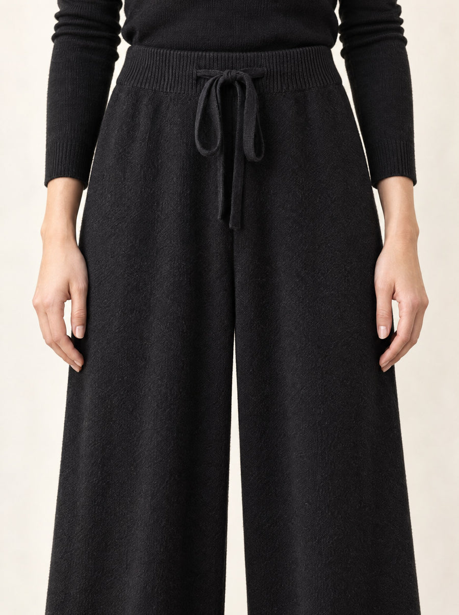 The ribbed waist and drawstring of the black trousers