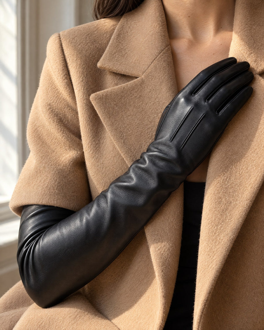 Black glove resting against a camel coat lapel