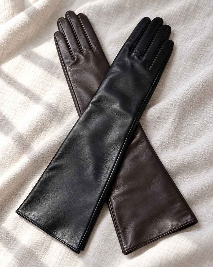 A black glove crossed over a dark chocolate glove on white linen