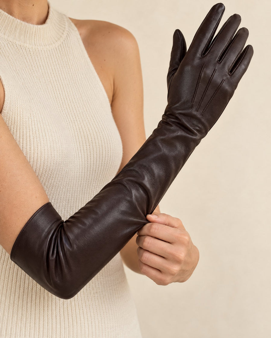 A dark chocolate glove being pulled up the arm